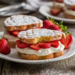 Fried Strawberry Cheesecake Sandwiches with powdered sugar and fresh strawberries